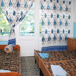 На фото: комната с окном и выходом на балкон, три кровати, прикроватная тумбочка